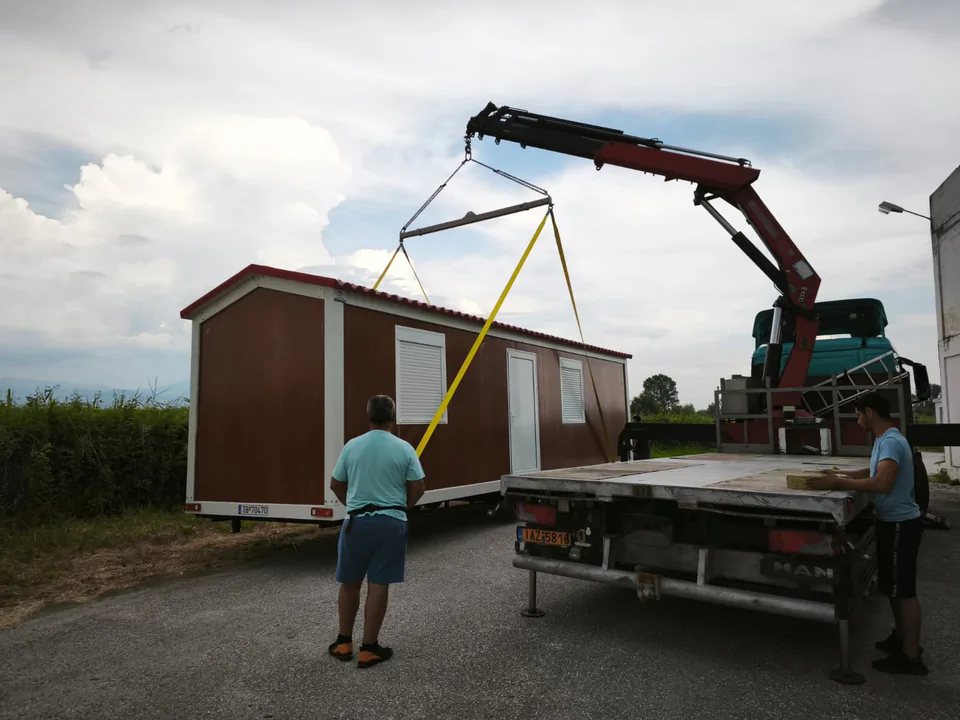 The unit being lowered by crane, guided by a technician