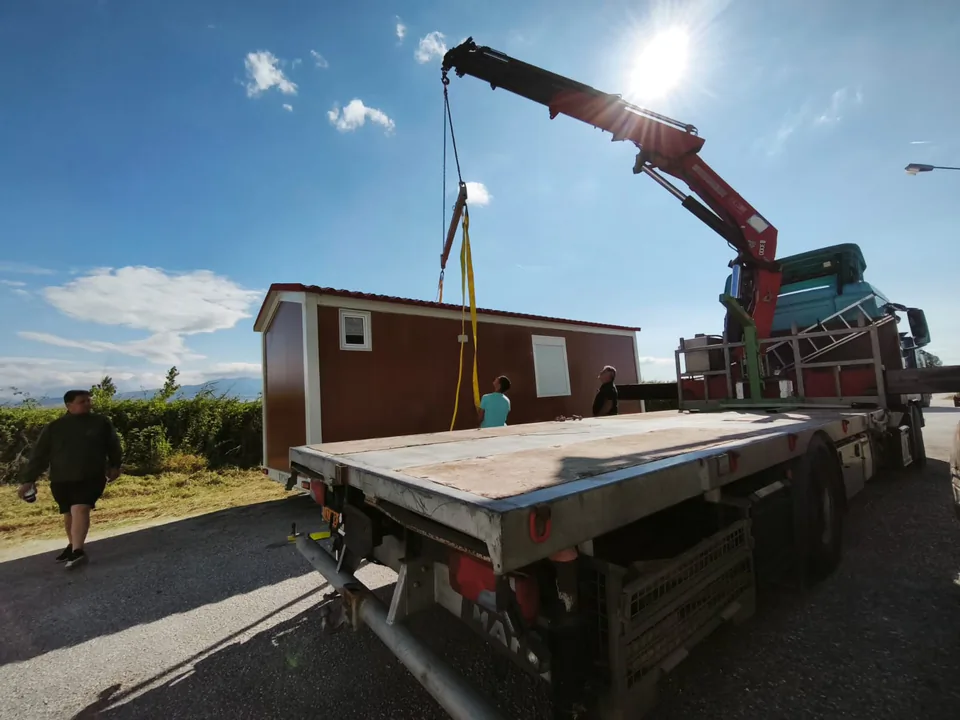 Crane lifting a unit against the sun