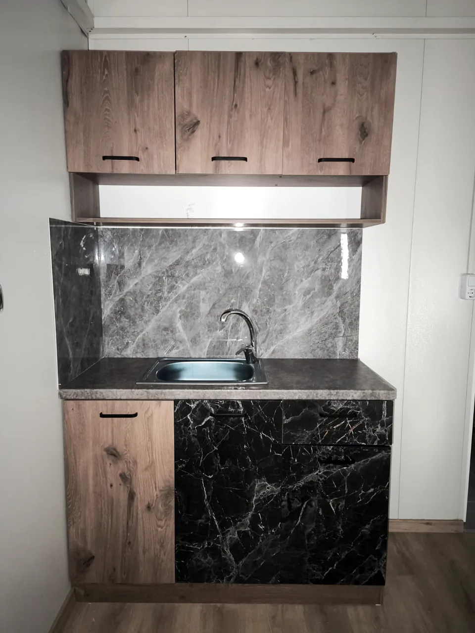 Kitchen with timber cabinets and a black marble-look splashback