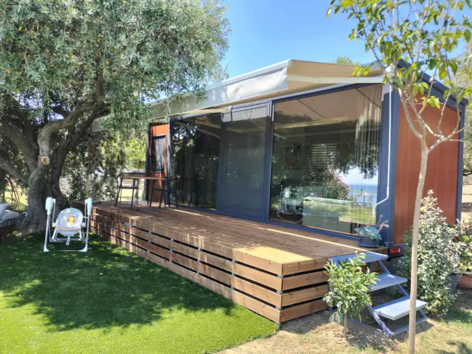 Nature Line with a timber deck and awning in a garden with olive trees